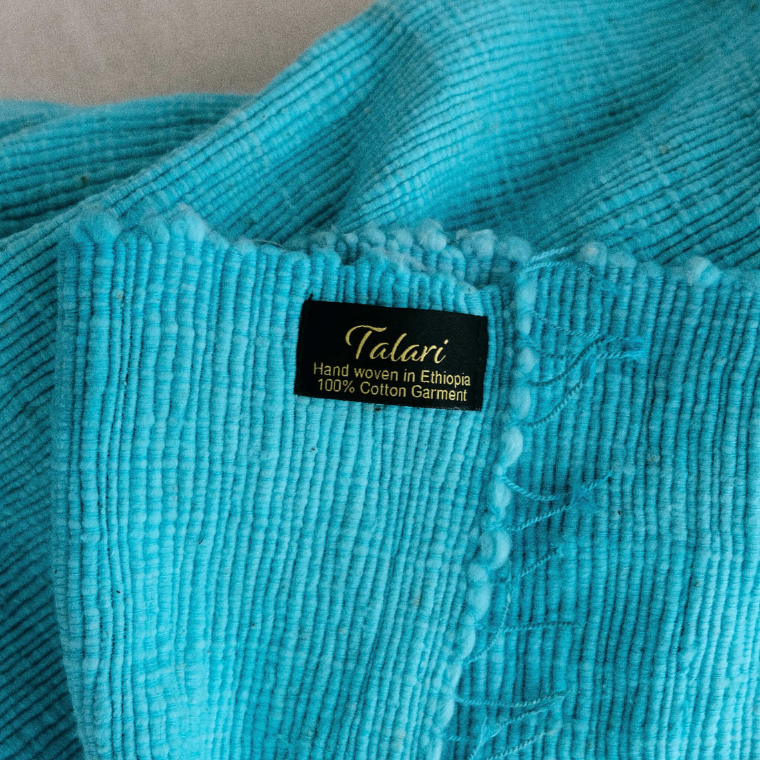 Closeup of a blanket made by Talari, with a label that shows the Talari logo.